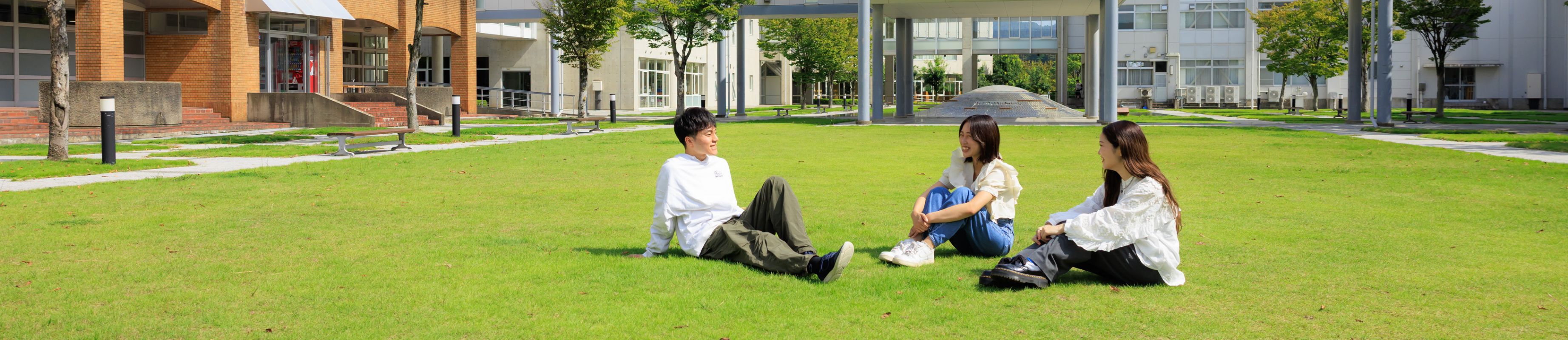 芝生で談笑する学生たちの写真