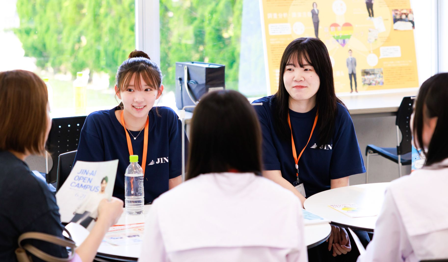 オープンキャンパスで親子に説明する学生の写真